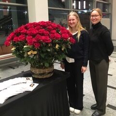 Noa Wischmann und Lara Skibbe helfen bei der Rosenübergabe